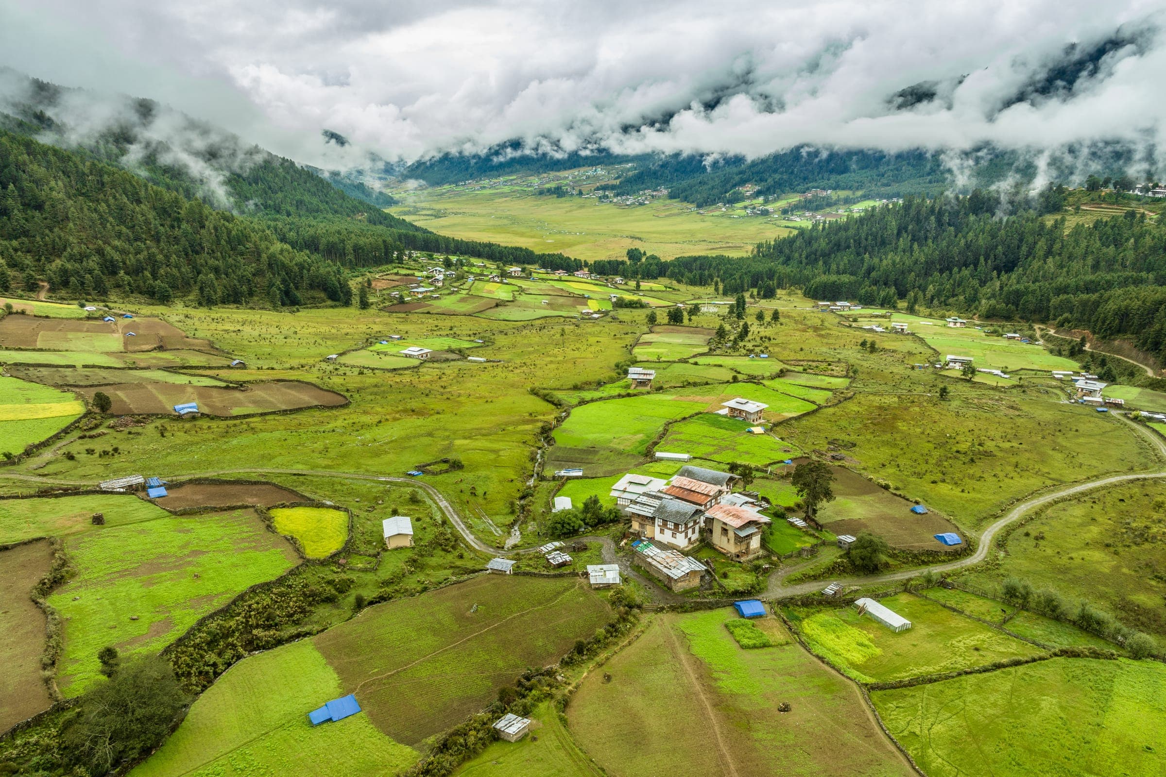 The wide green Phobjikha valley beneath low cloud
