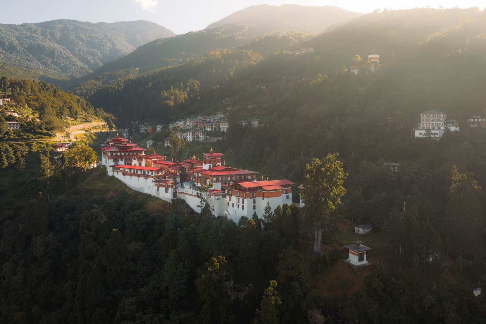 Trongsa Dzong lit at dusk, spread along its ridge above the gorge