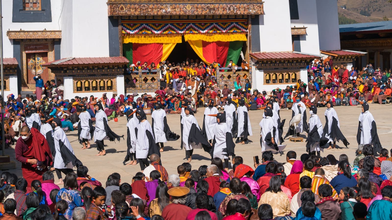 Dancers performing in a dzong courtyard during a festival