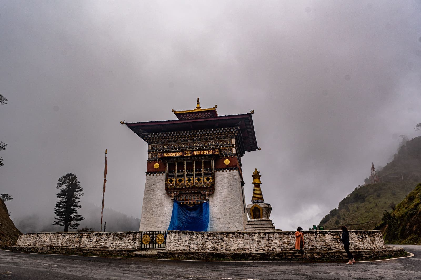 A Bhutanese gateway on the road under a stormy sky